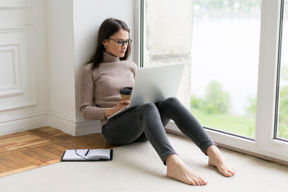 Chica sentada en el suelo buscando precio psicólogo online